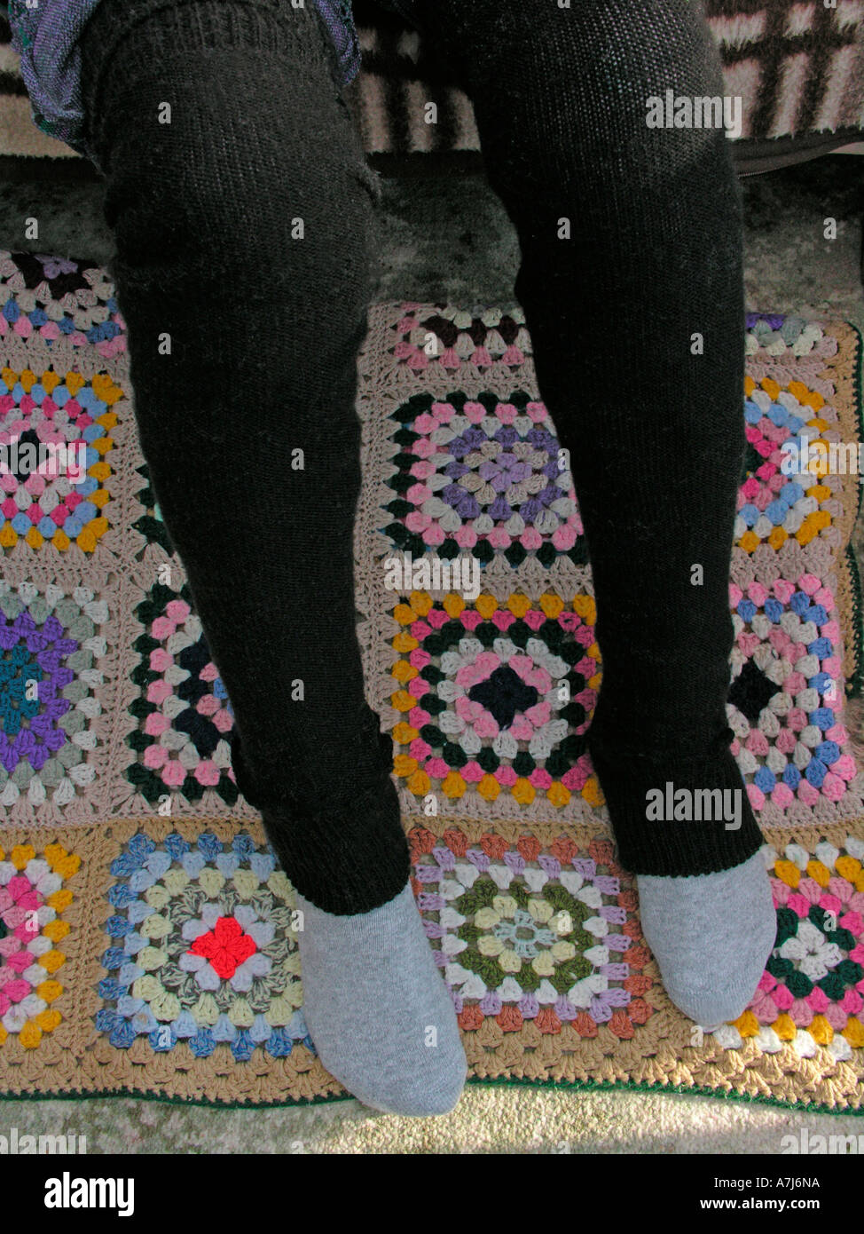 elderly woman wearing leg warmers to keep her arthritic legs with varicose veins warm and cosy