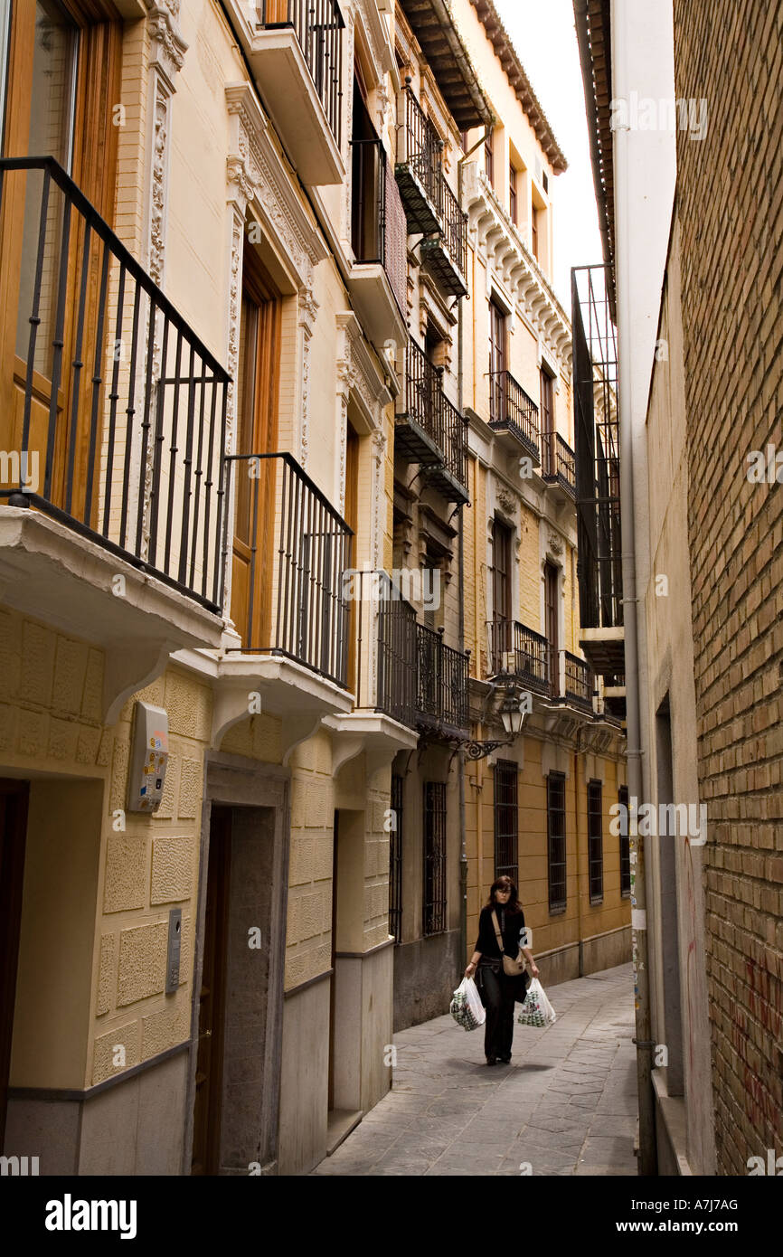 Girl carrying groceries shopping through narrow street Granada Spain Stock Photo