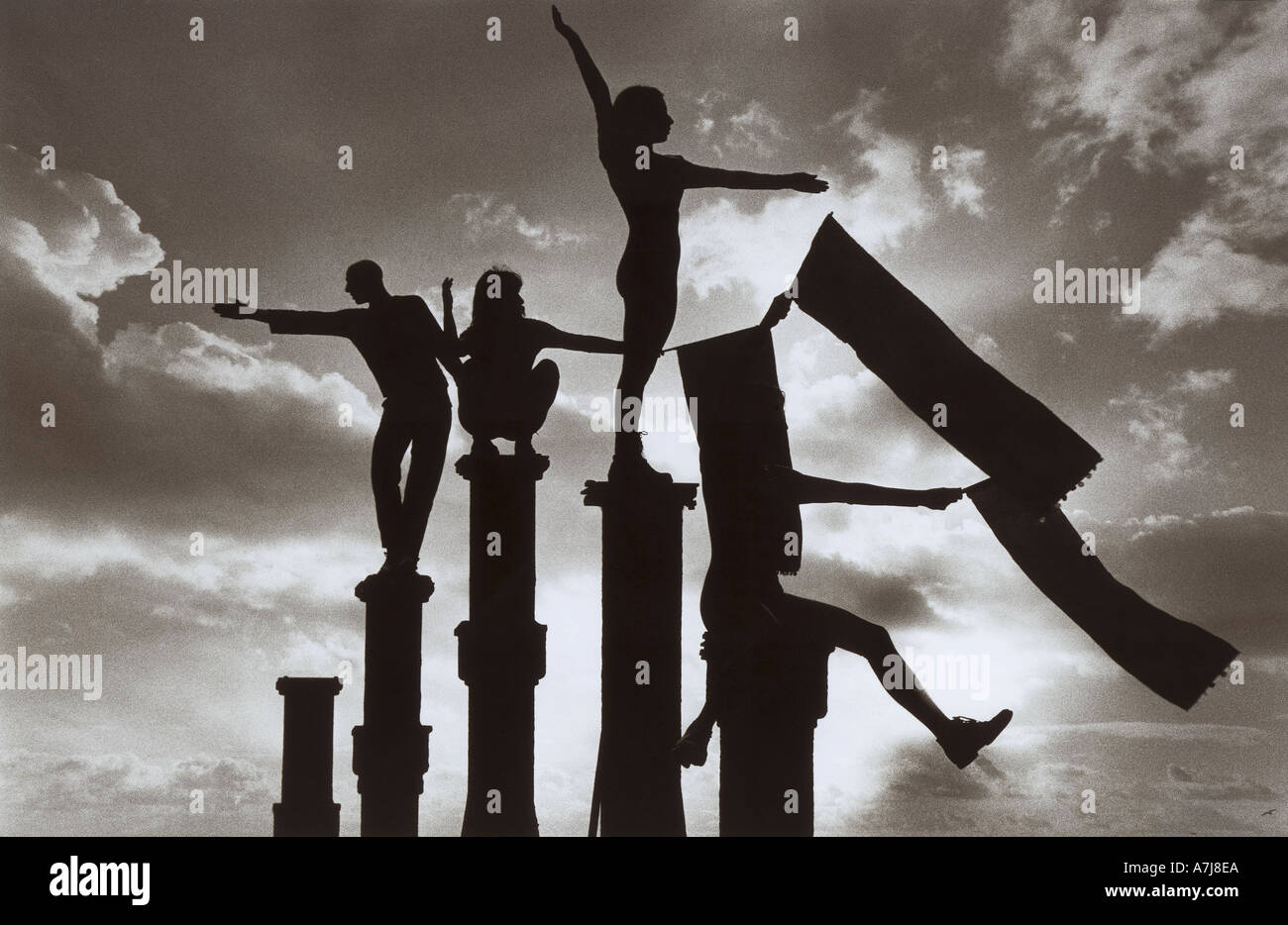 Graceful silhouettes of dancers balancing on posts as part of  Brighton Festival 1995 Stock Photo