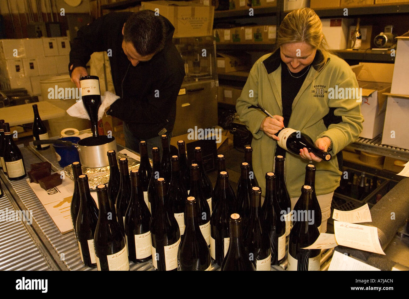 Hand labeling new bottling of pinot noir, De Lancellotti Wine. Stock Photo
