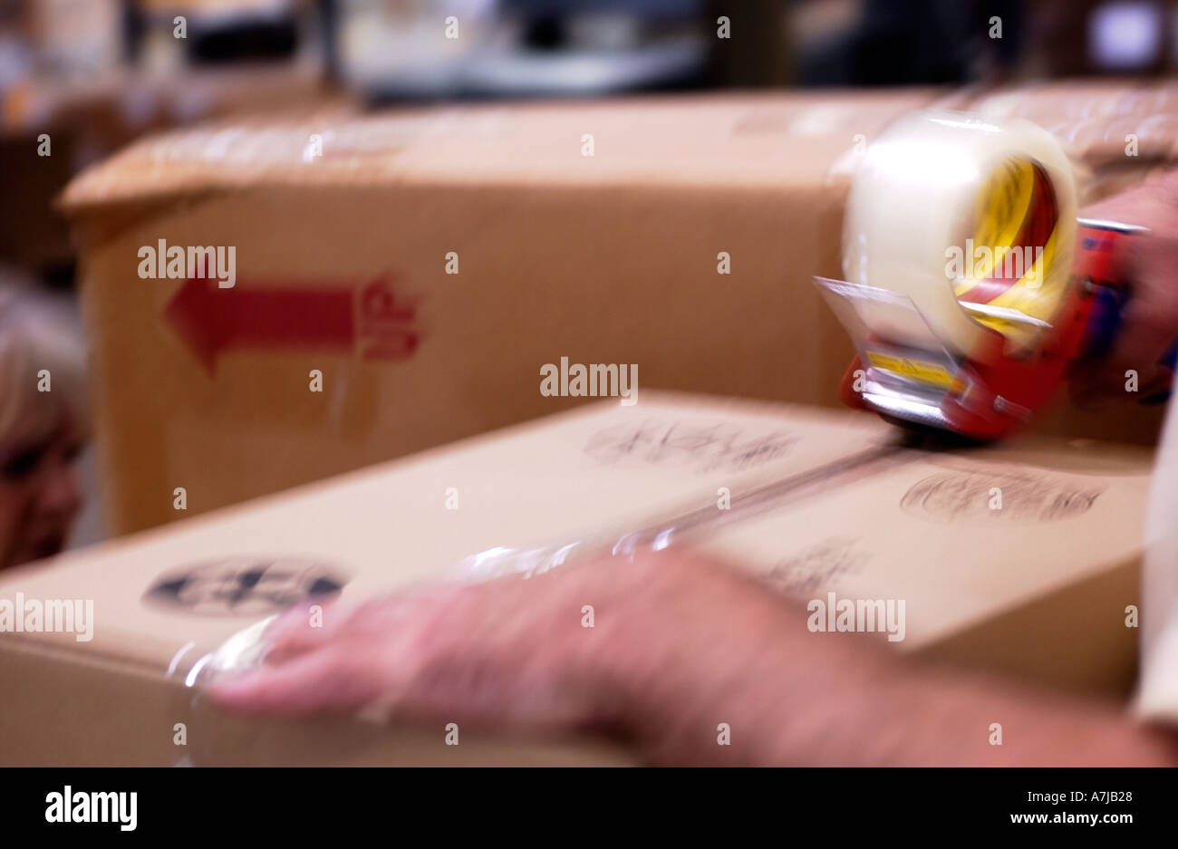 Warehouse worker taping cardboard boxes Stock Photo