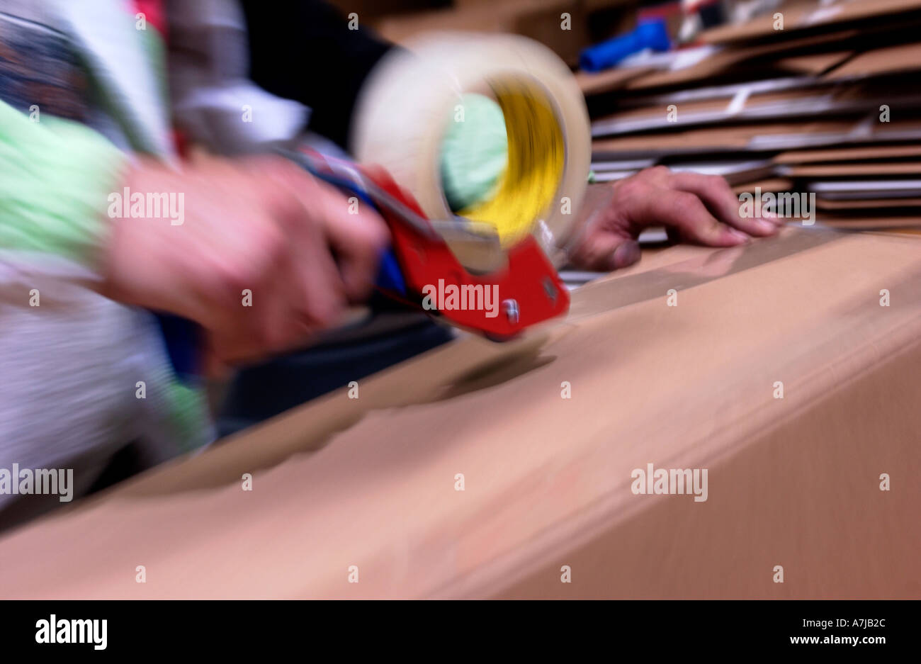 Warehouse worker taping cardboard boxes Stock Photo