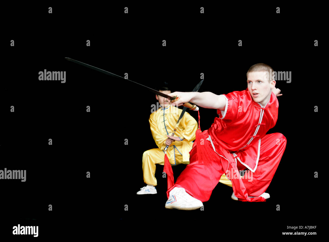 Marial Arts demonstrators from Ireland and china with swords and silk pyjamas outfit on stage during display Stock Photo