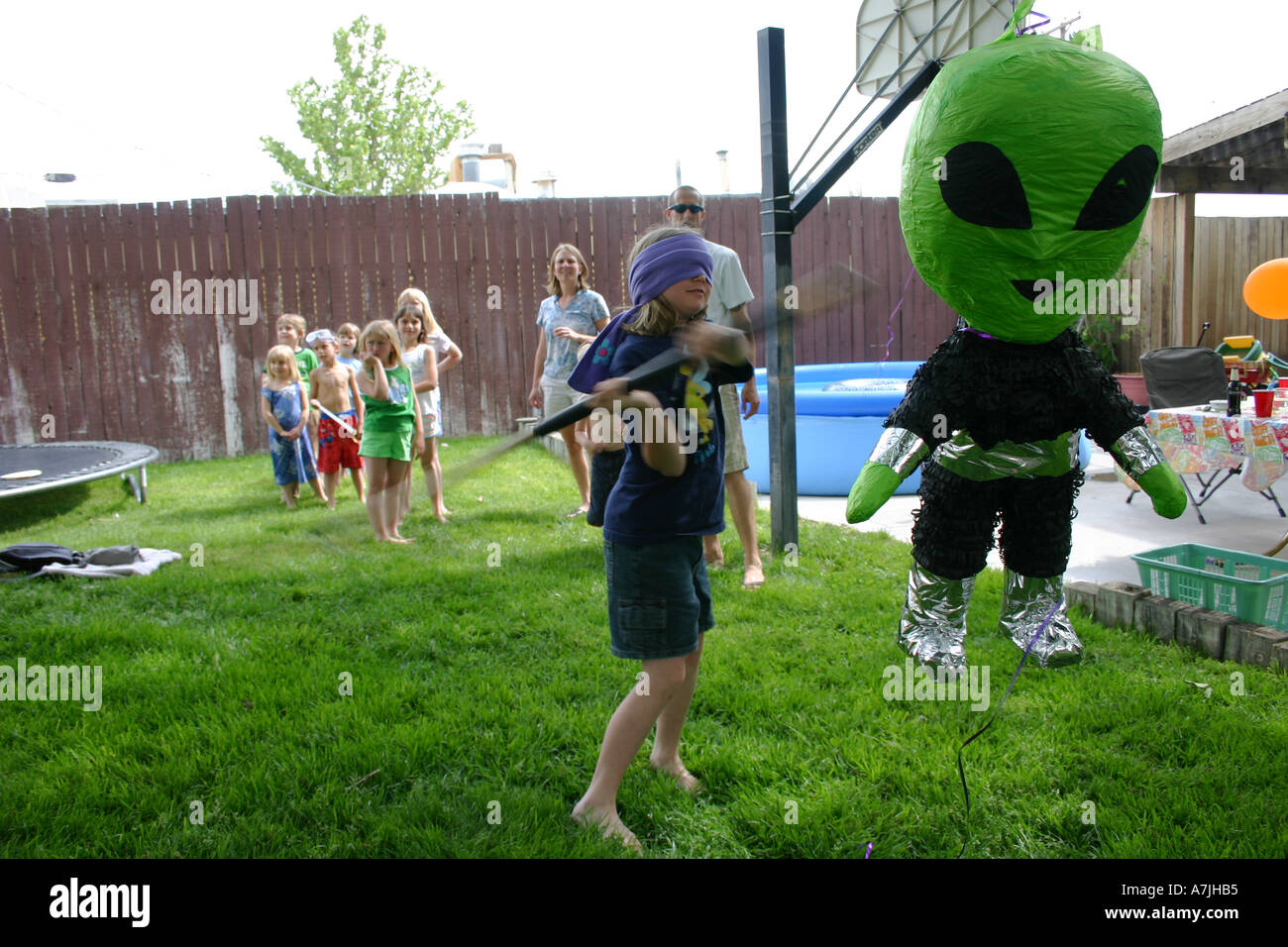 child hitting alien pinata at birthday party Stock Photo - Alamy