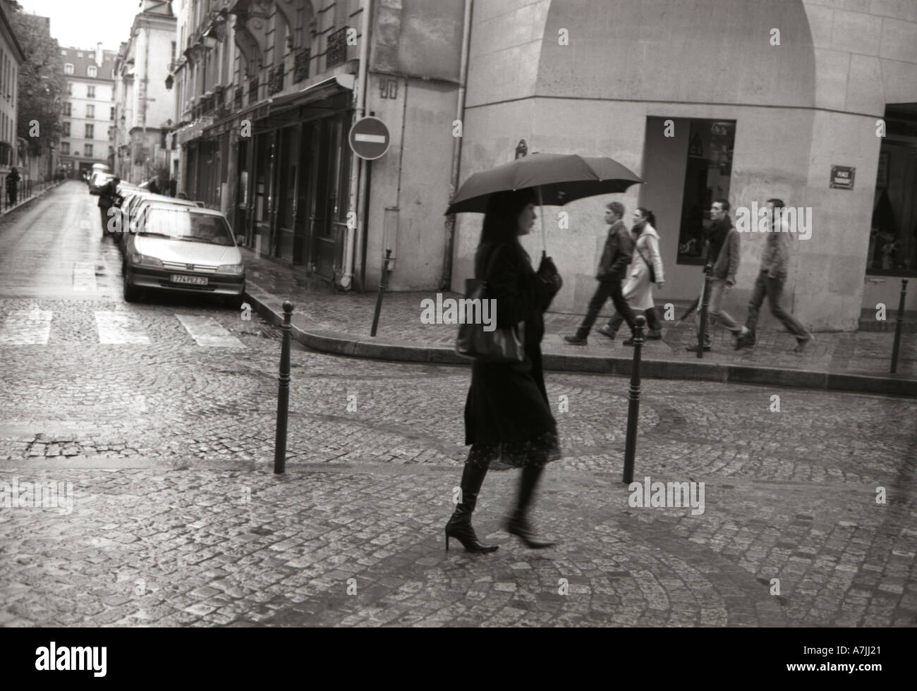 Woman walking in rain with umbrella in Paris Stock Photo - Alamy