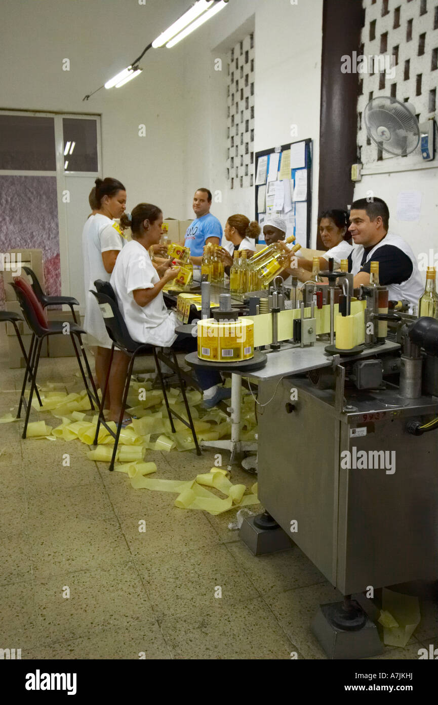 Workers in a rum factory putting labels on bottles, Havana Stock Photo