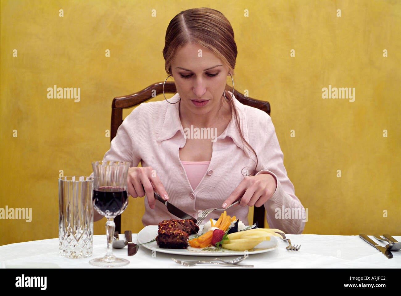 Woman Dining on Beefsteak at a Restaurant Table Stock Photo
