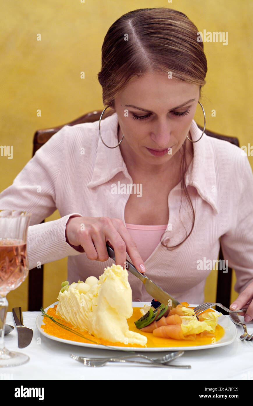 Woman Eating Smoked Salmon at a Restaurant Table Stock Photo
