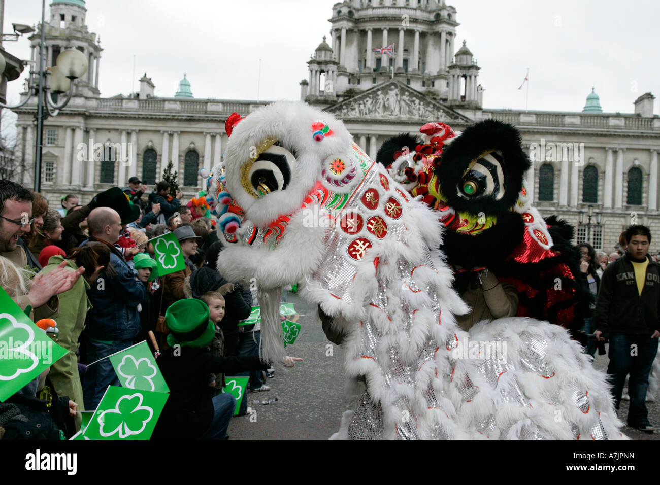 two Chinese dragons taking part in the st Patricks Day parade looking into crowd in front of Belfast City Hall 2007 Stock Photo