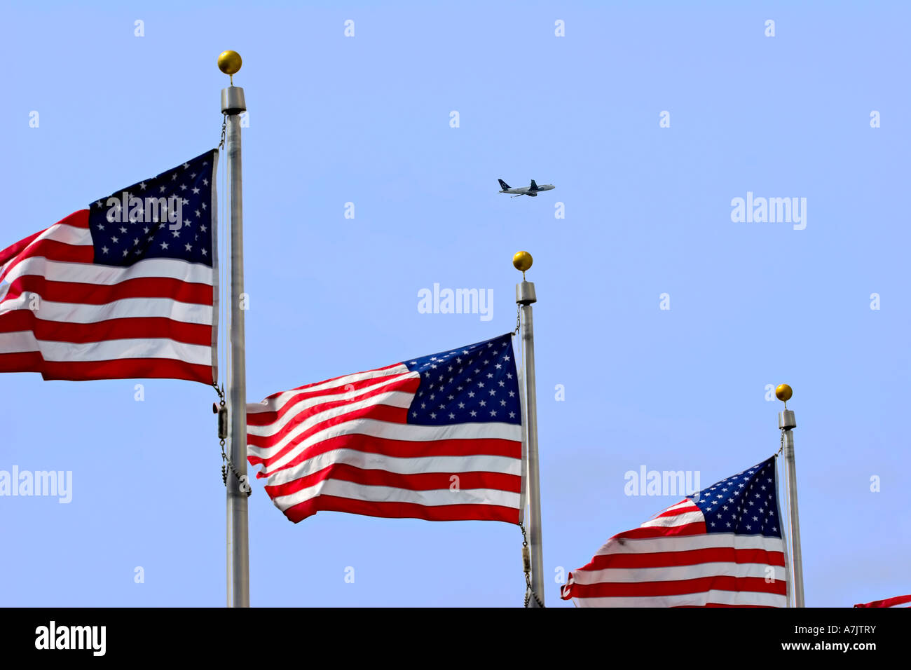 Plane from Reagan National Airport on ascent past a display of flags at the Washington Monument. Stock Photo