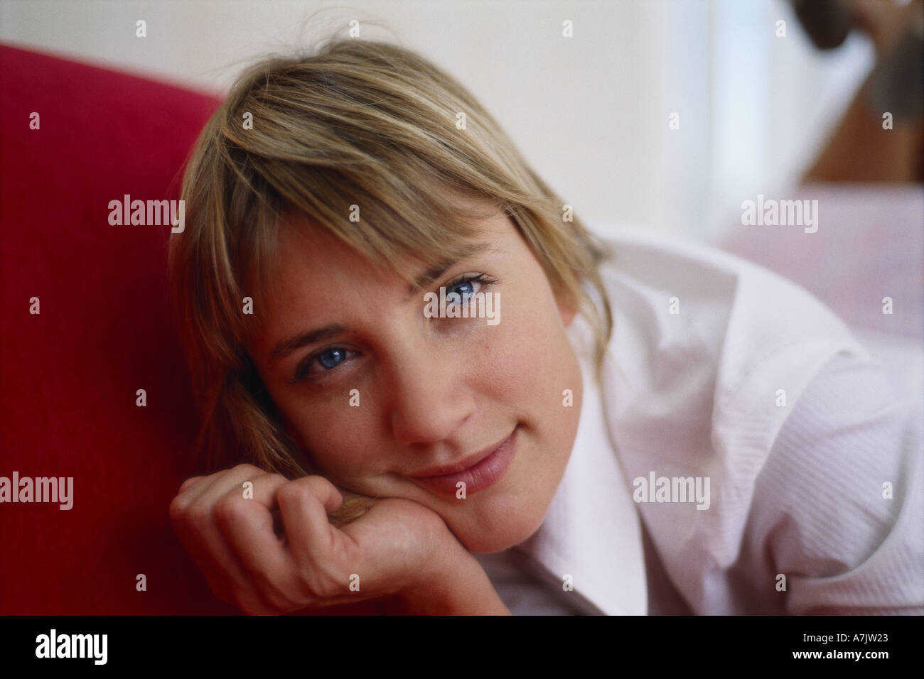 Portrait of a young woman lying on a couch Stock Photo - Alamy