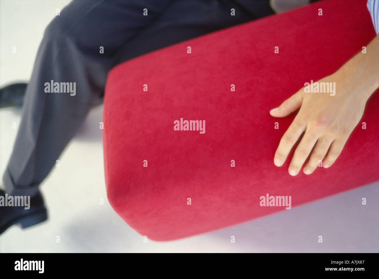 Low section view of a person sitting on a couch Stock Photo - Alamy