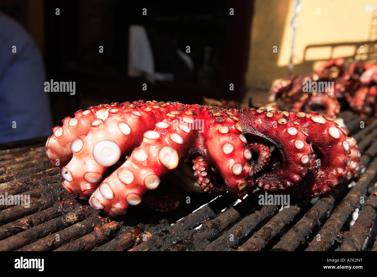 GREECE SARONIC GULF EGINA ISLAND A BUSY TAVERNA IN THE BACK STREETS OCTOPUS COOKING Stock Photo