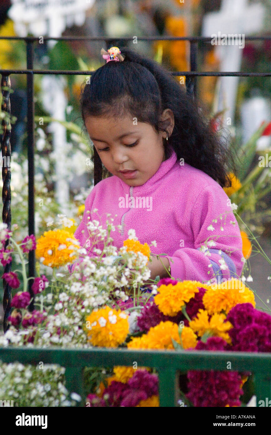 A young MEXICAN girl visits a grave during the DEAD OF THE DEAD SAN MIGUEL DE ALLENDE MEXICO Stock Photo