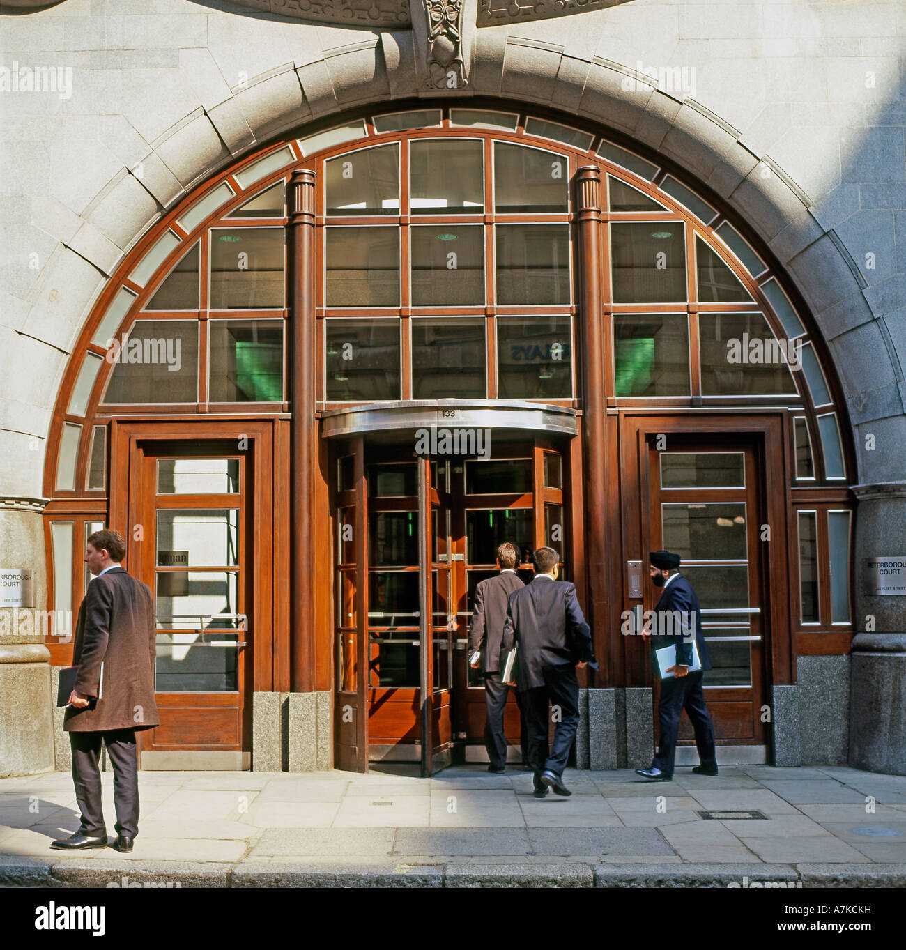 Businessmen outside the entrance of Goldman Sachs Office headquarters  in Fleet Street City of London England UK  KATHY DEWITT Stock Photo