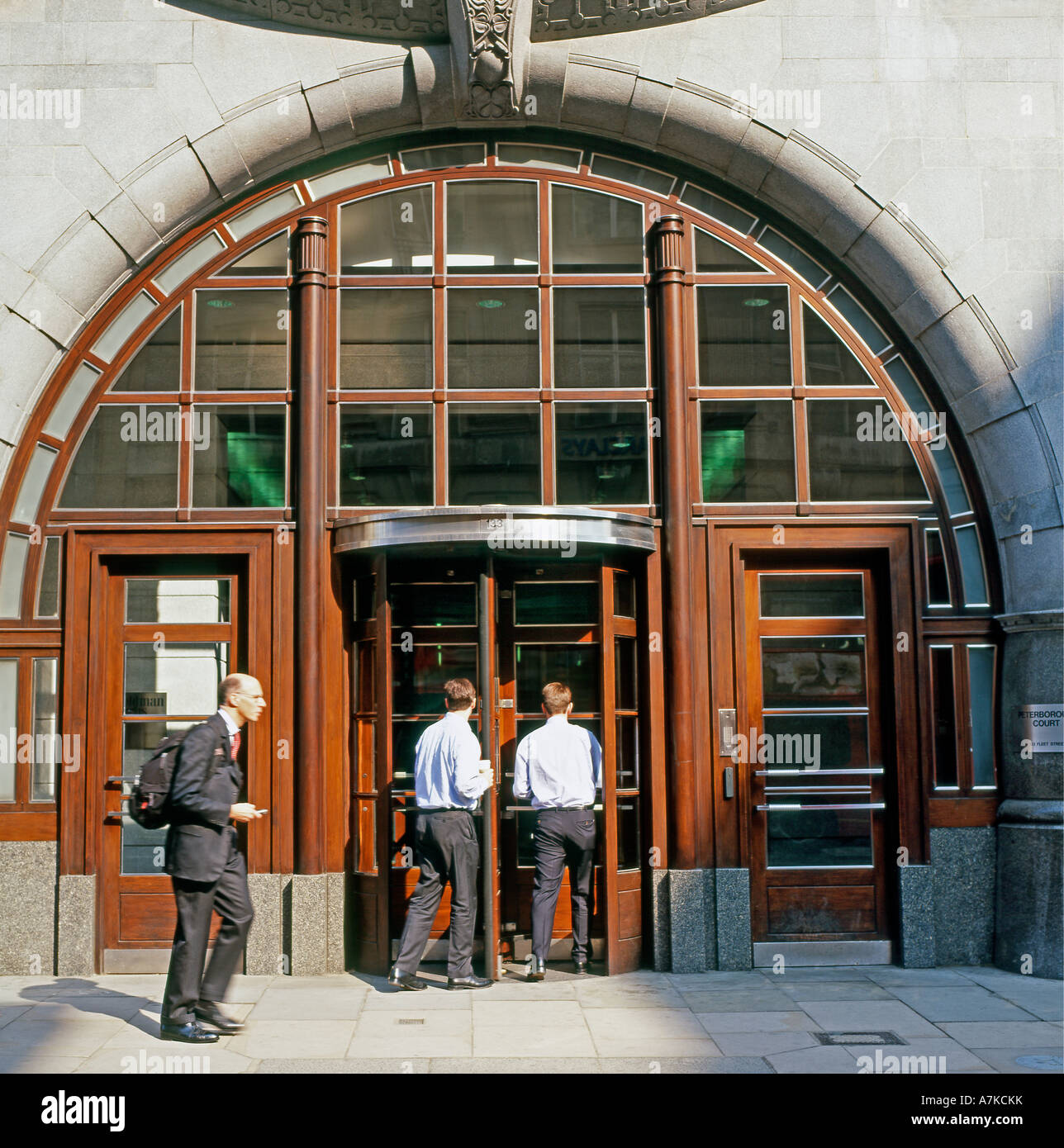 Businessmen at the entrance of the Goldman Sachs Office Headquarters in  Fleet Street London England UK  KATHY DEWITT Stock Photo