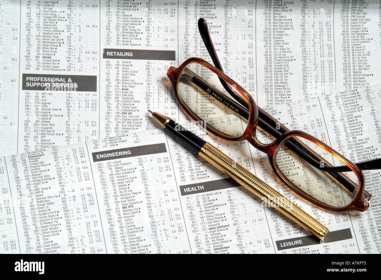 checking list of stocks and shares markets in detail on newspaper page equity prices lens lenses