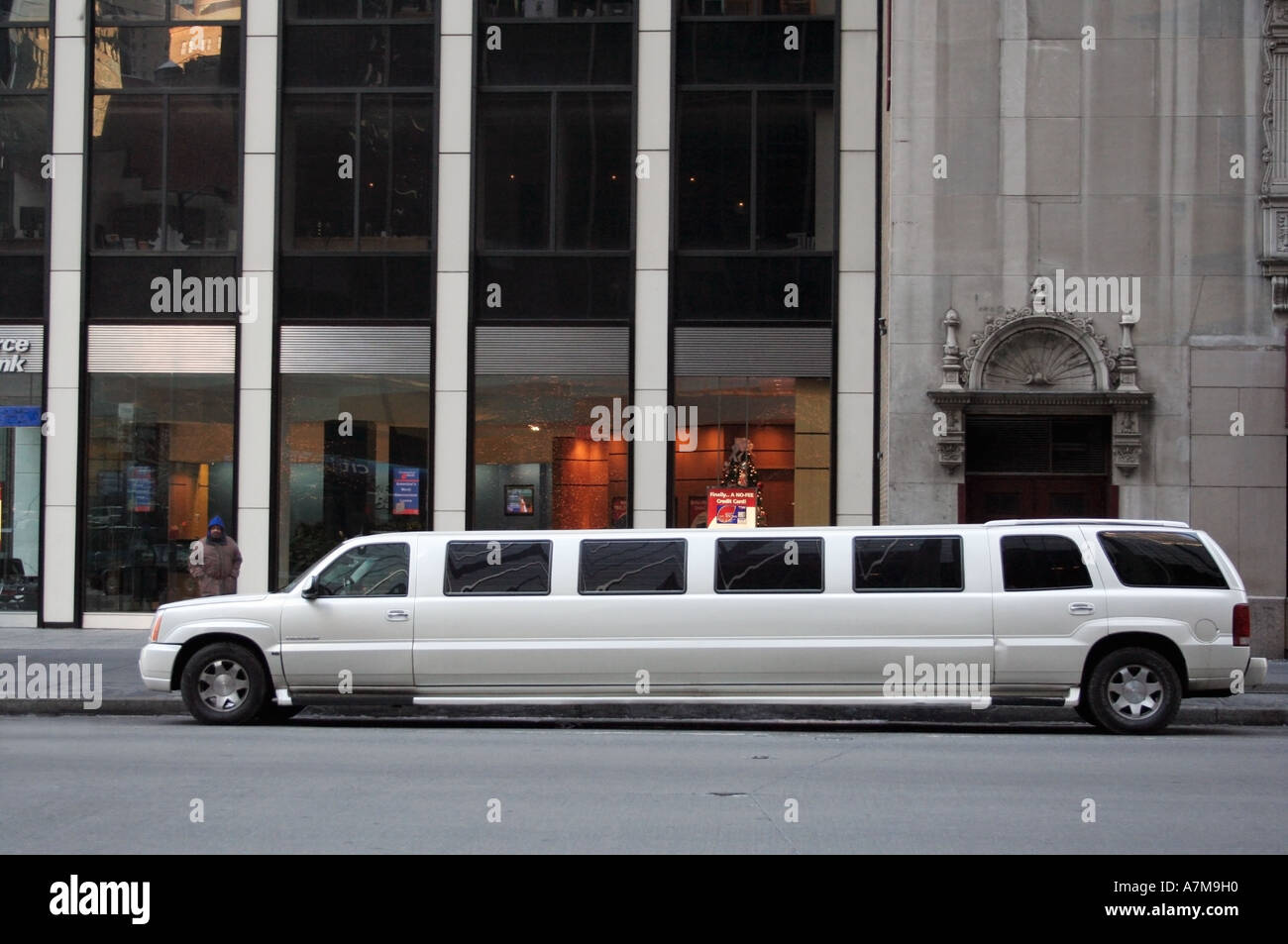A white stretch limo parked up. New York city. USA. Pedestrian on-looker on the sidewalk. Stock Photo