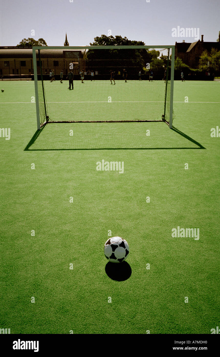 Soccer ball in front of goal with players training in background Stock Photo