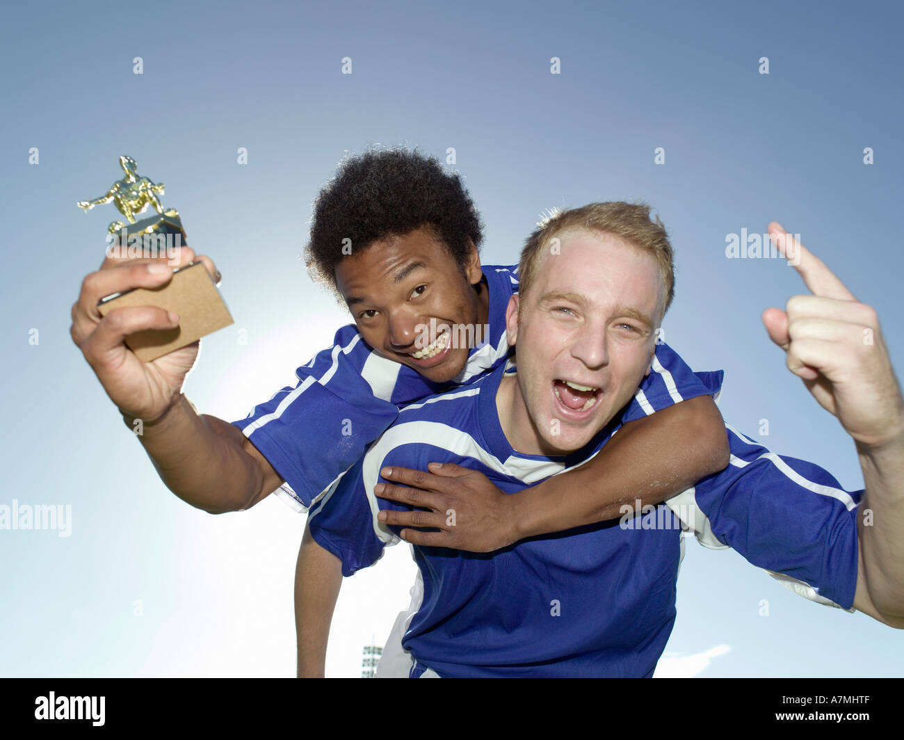 Two soccer players celebrating with a trophy Stock Photo