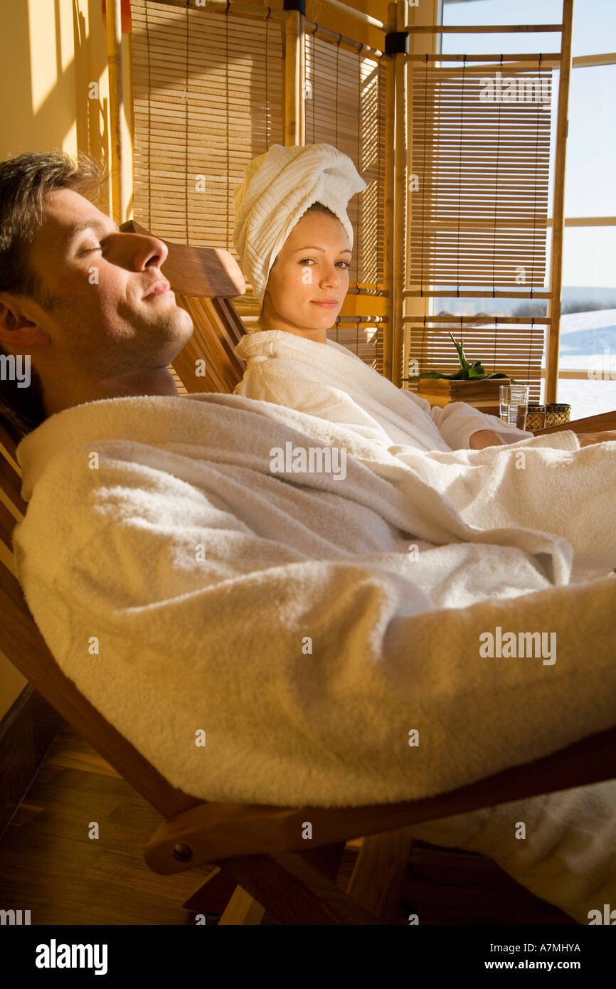 Couple reclining on chairs in bathrobes Stock Photo