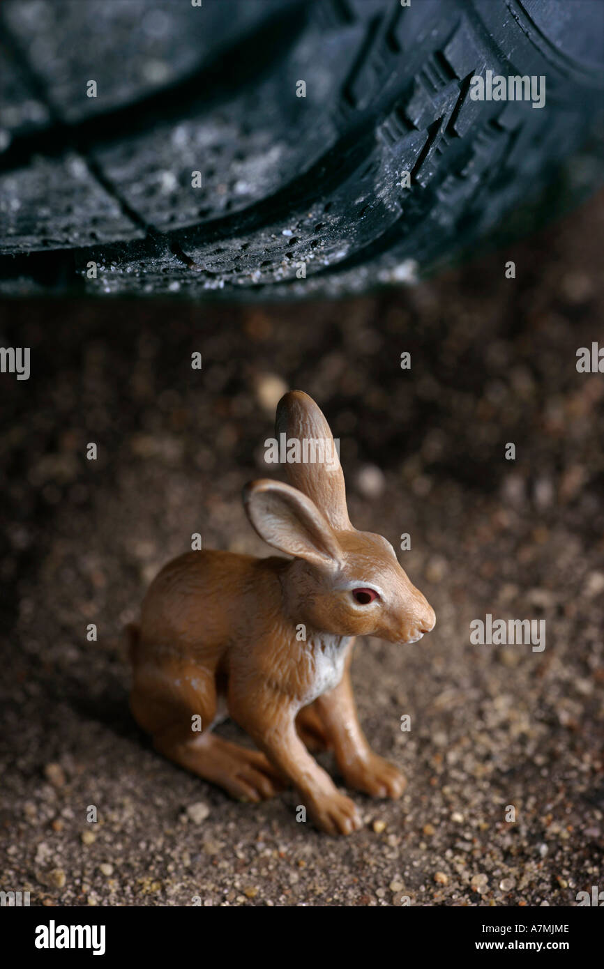 Rabbit figurine under car tire Stock Photo Alamy