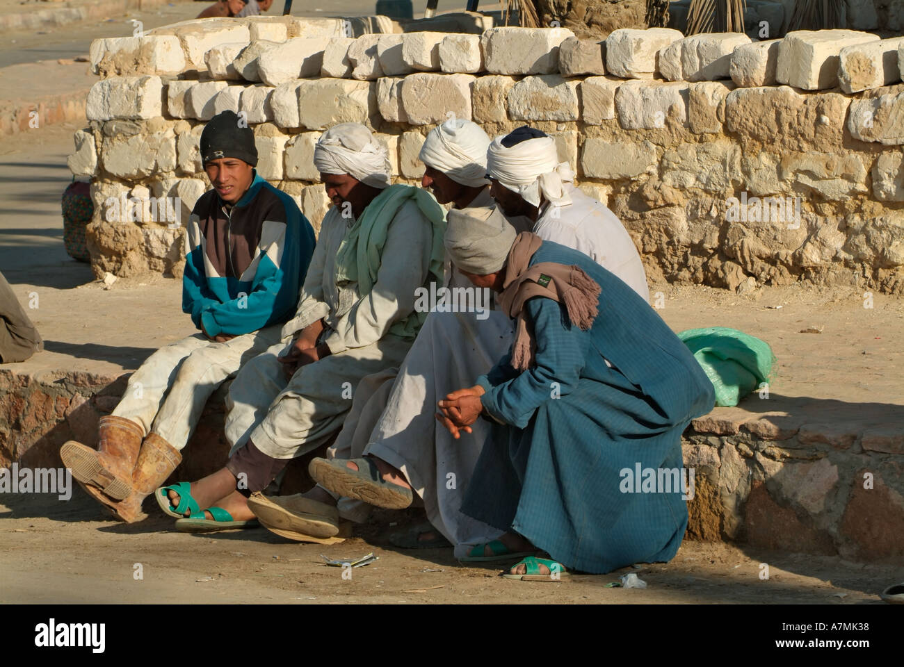 Egyptian men sitting on the roadside, Siwa, Egypt Stock Photo