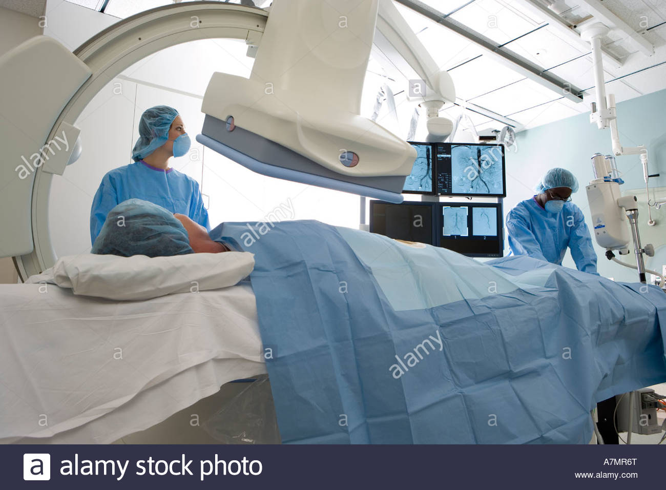 Doctors in scrubs and surgical masks scanning patient lying on Stock ...