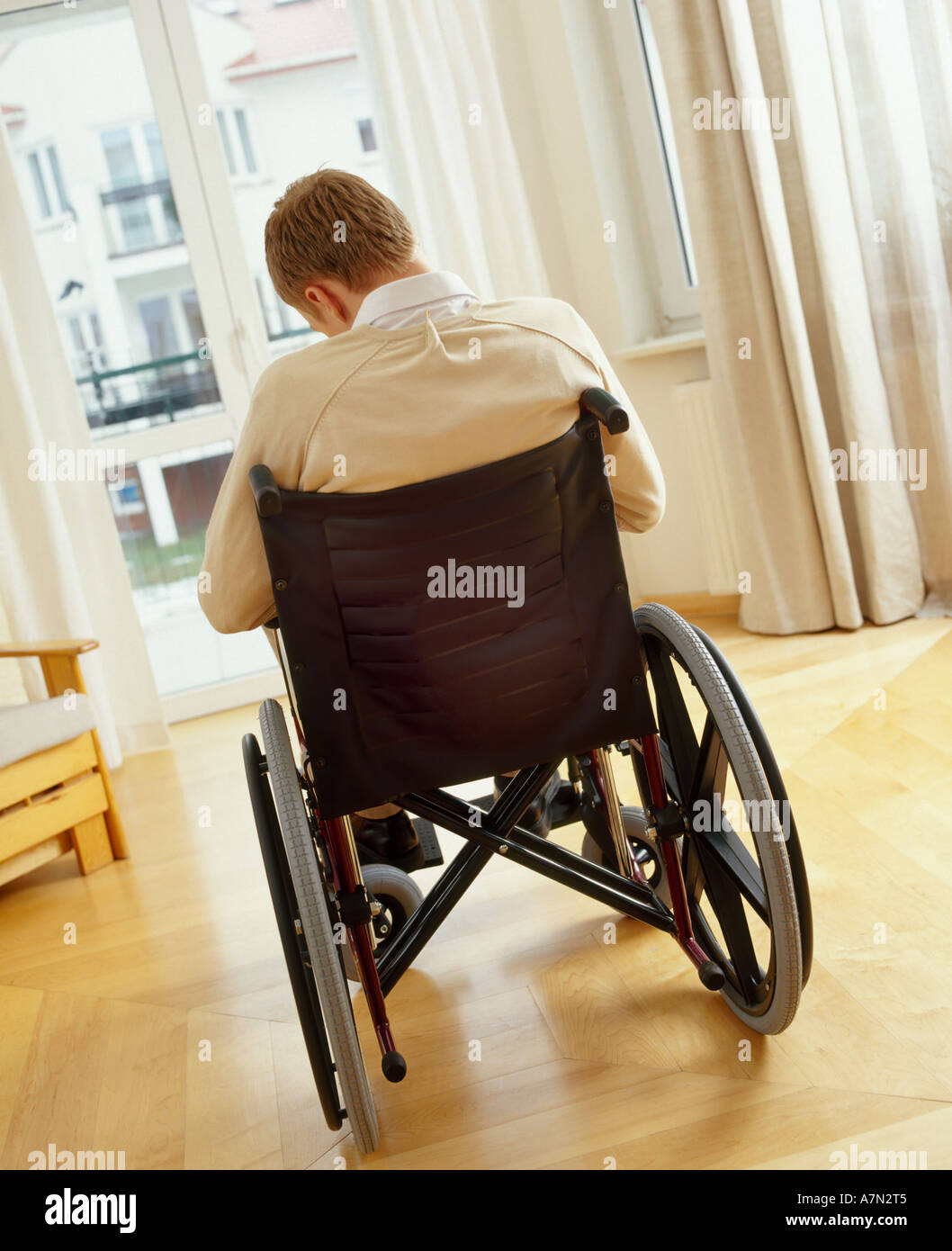 indoor flat room livingroom man boy young blonde sit back wheelchair
