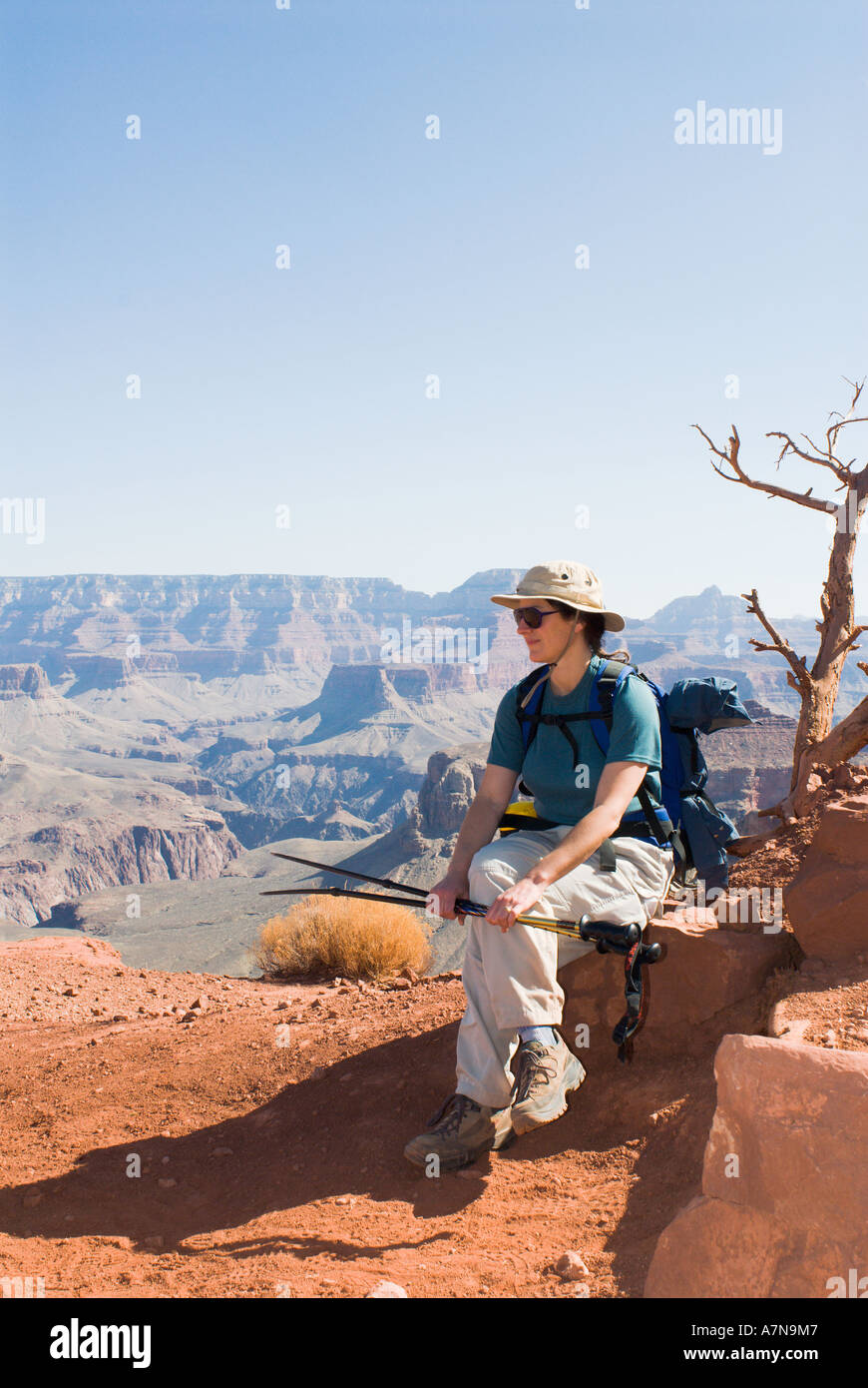 A woman hiker rests along the South Kaibab Trail while decending into the Grand Canyon Stock Photo
