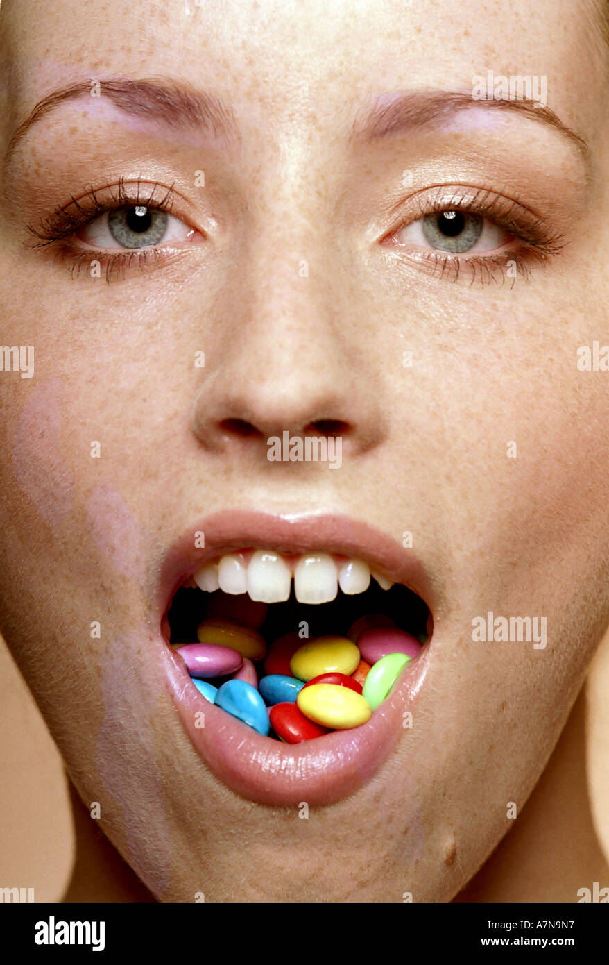 indoor studio woman young girl 20 25 freckle freckles hold mouth pill pills tab tabs tablette teblettes medicine medicines re Stock Photo