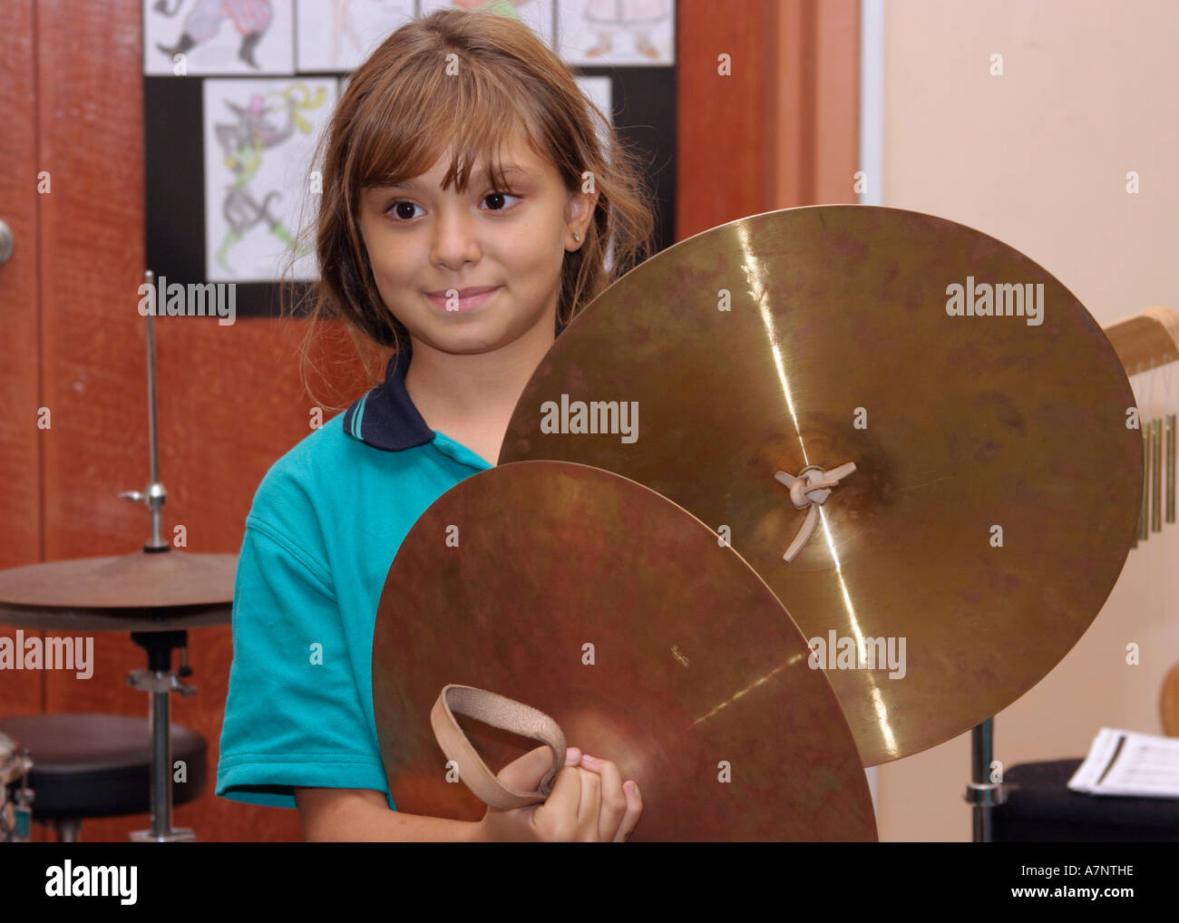 young girl playing cymbals in music lesson at school Stock Photo