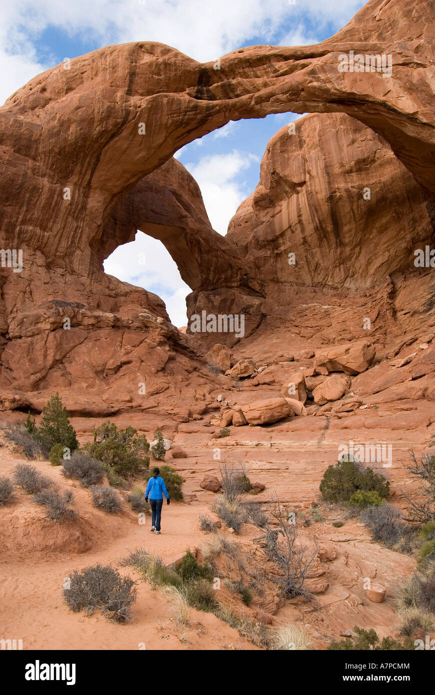 Woman walking on trail to Double Arch Arches National Park Utah USA Stock Photo