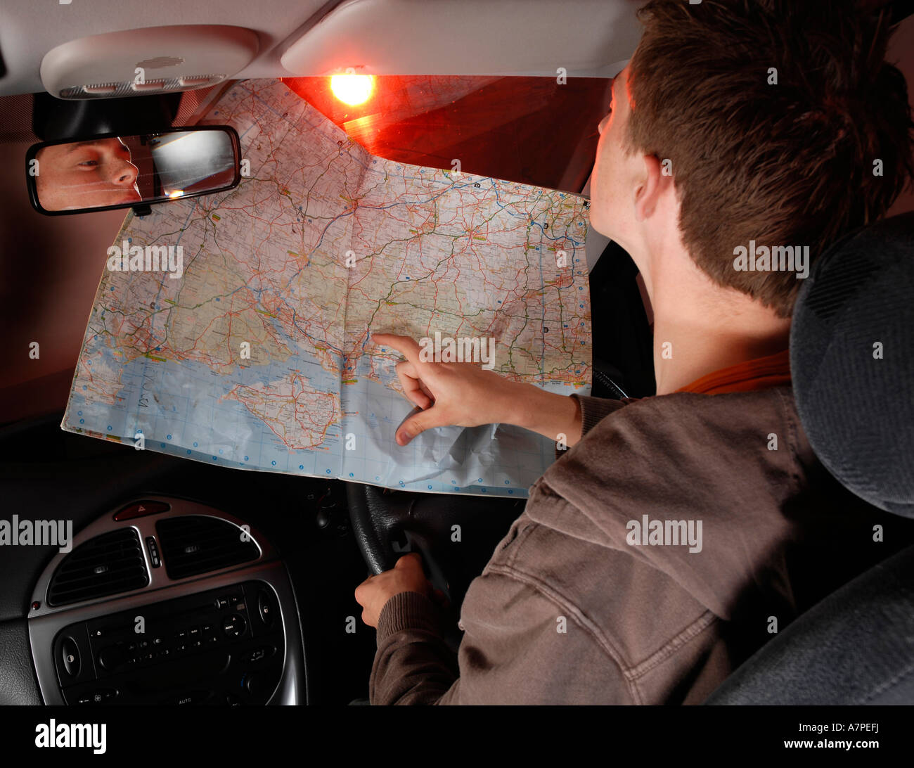 young-man-reading-a-map-while-driving-A7