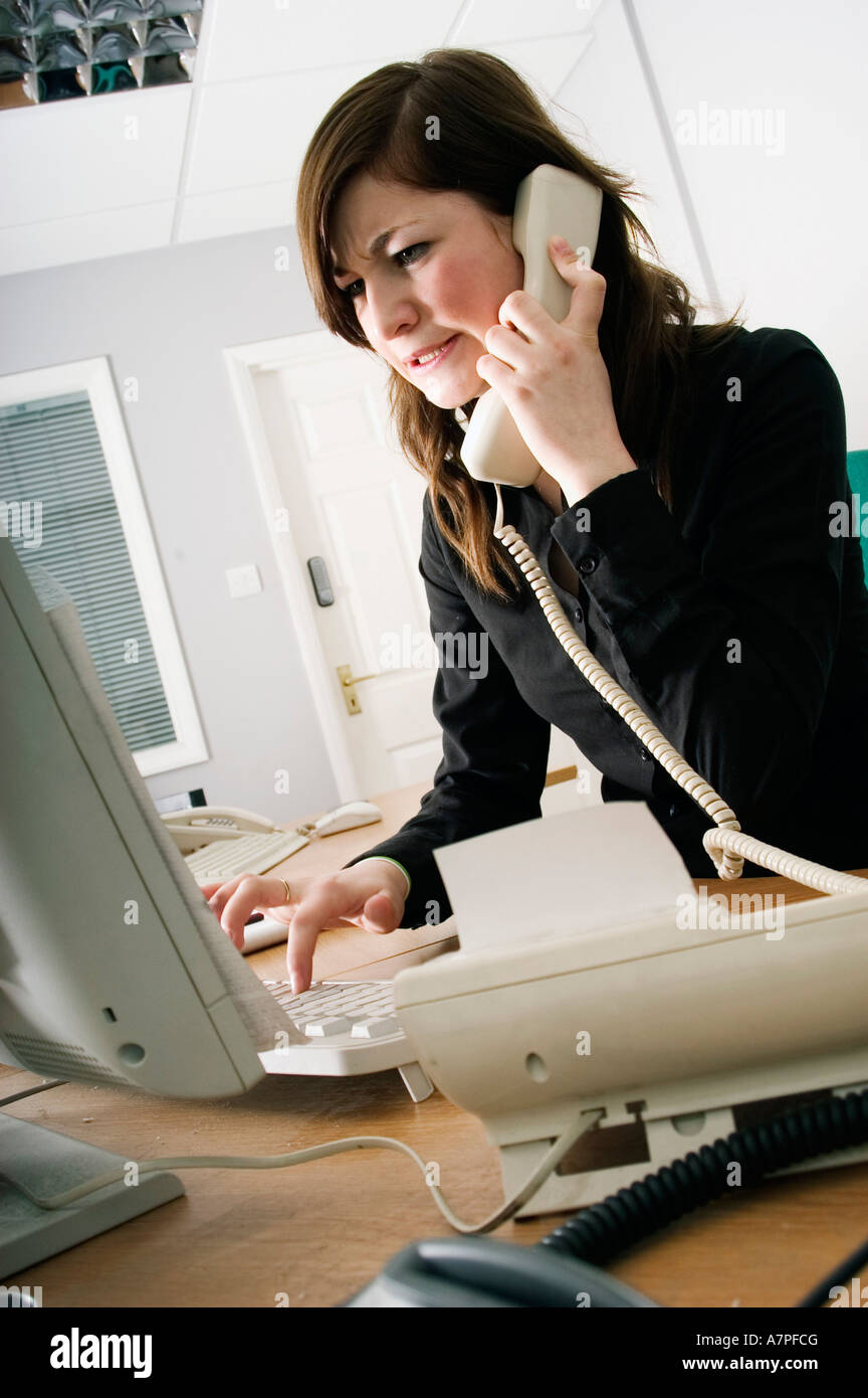 Stressed office girl secretary on the telephone Stock Photo