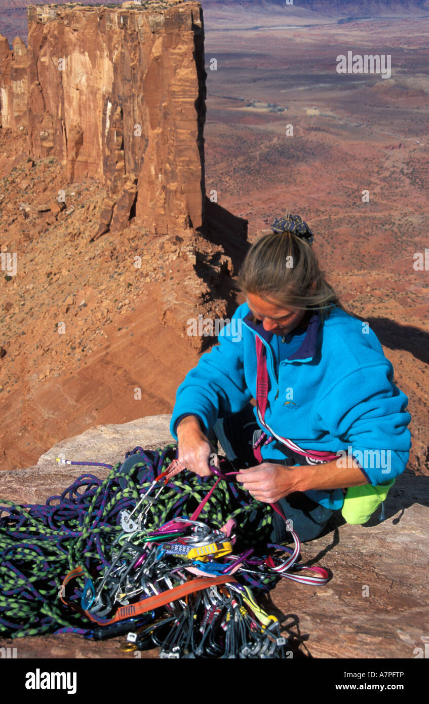Female climber sorting out her climbing gear on the summit at