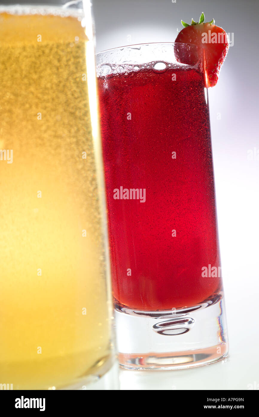 Brightly colored sparkling carbonated fruit drinks with strawberry garnish Stock Photo