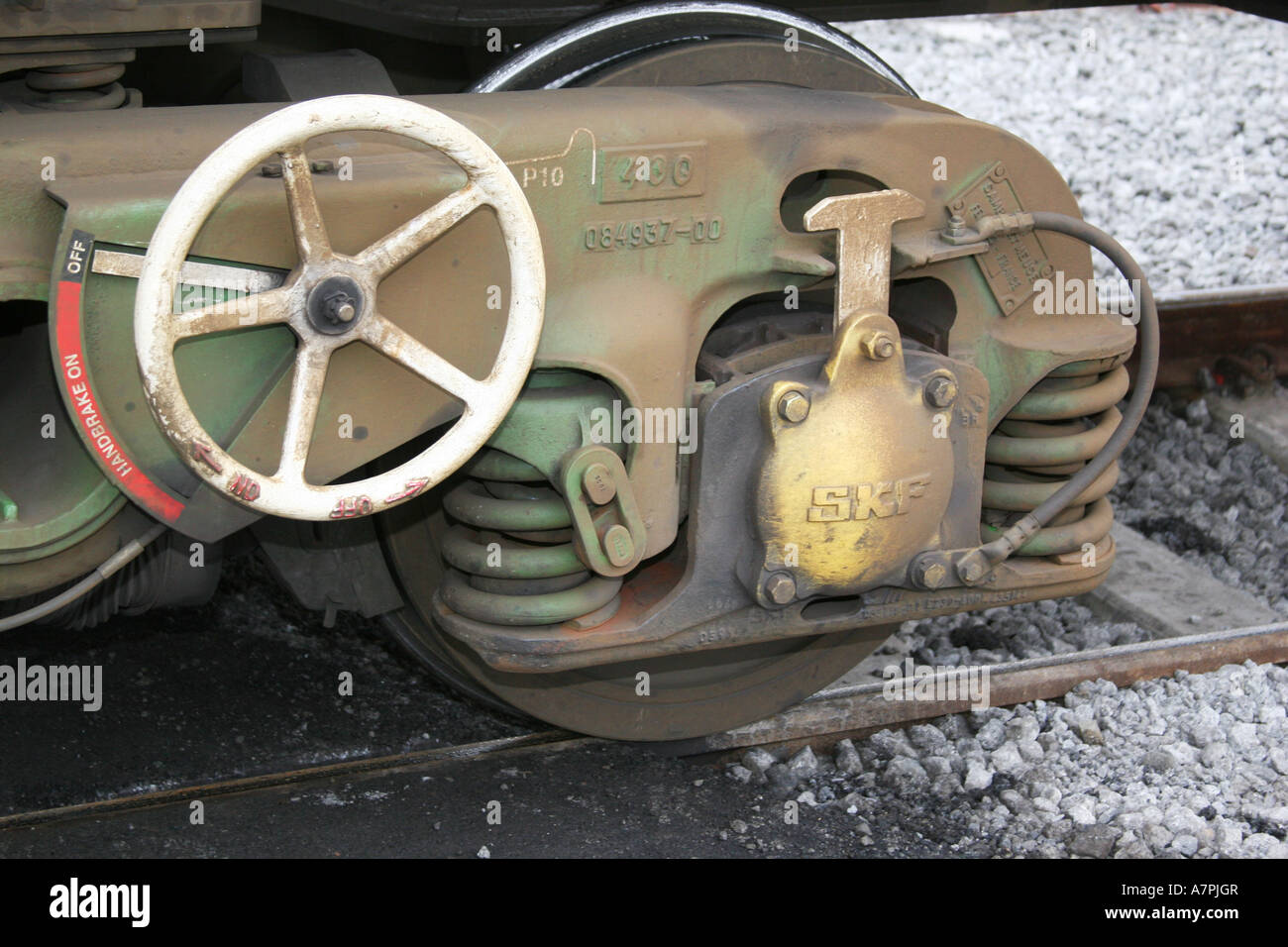 Large bogie on modern rail wagon showing manual wheel handbrake. Stock Photo