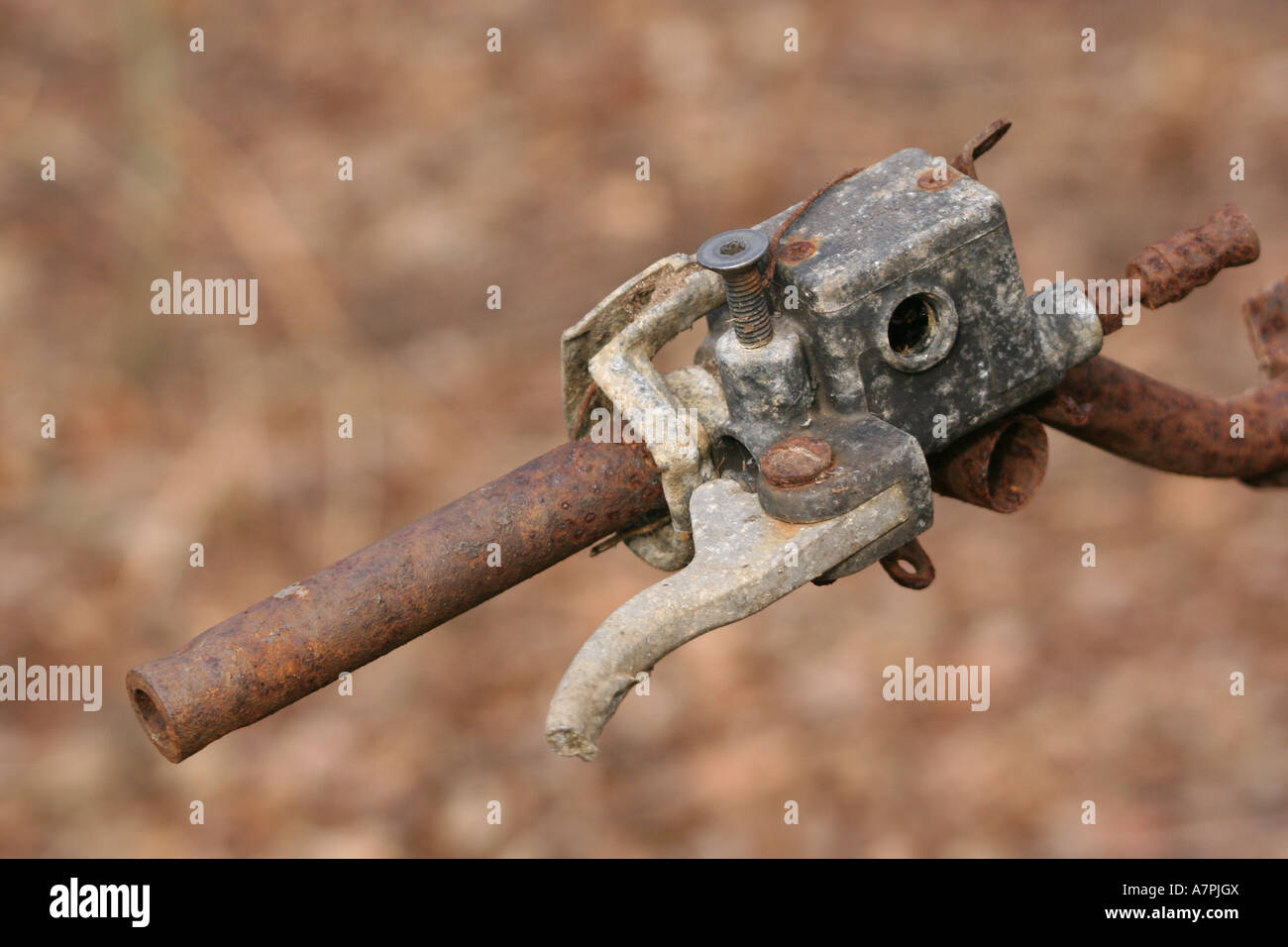Corroding handle bar and grip of old motorcycle dumped in woodland. Stock Photo