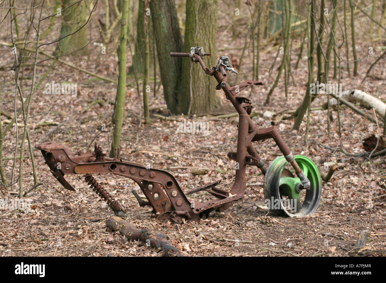 Dumped and stripped wreck of motorbike in woodland Stock Photo - Alamy