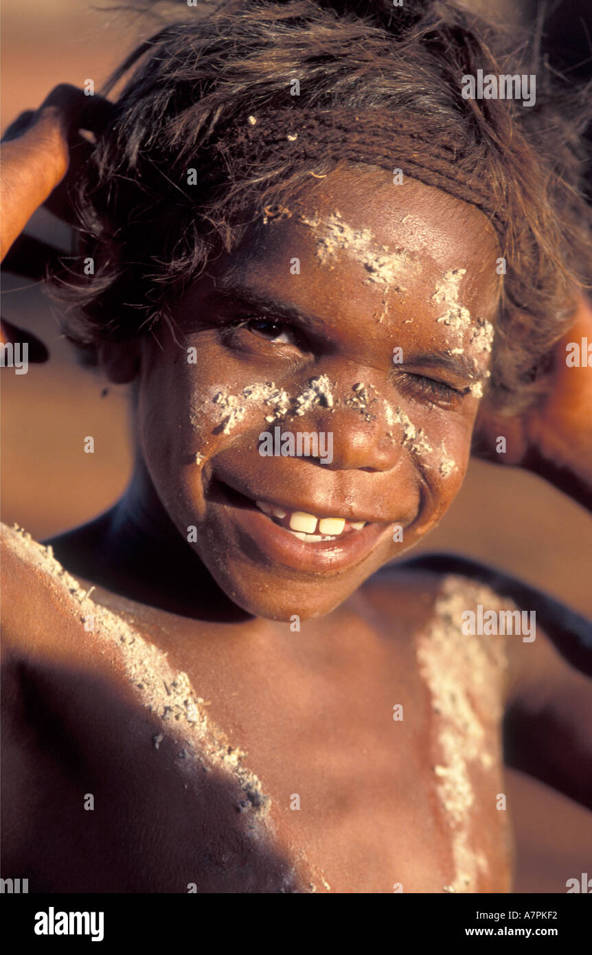 Smiling happy Aboriginal boy painted up for corroborree ceremony in desert south of Alice Springs Central Australia Stock Photo