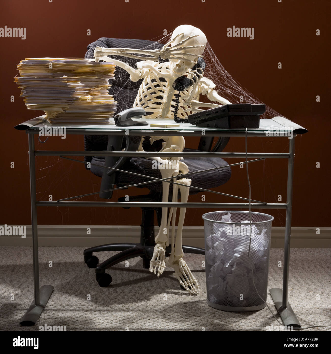 Skeleton Sitting At Desk Talking On Telephone With Webs And Stacks