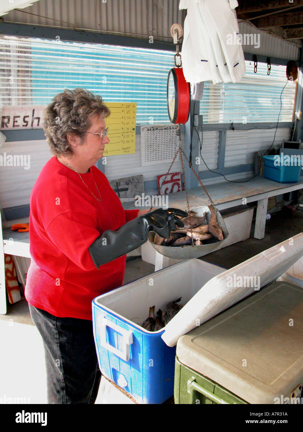 Woman selling fresh seafood on the side of the road at small market