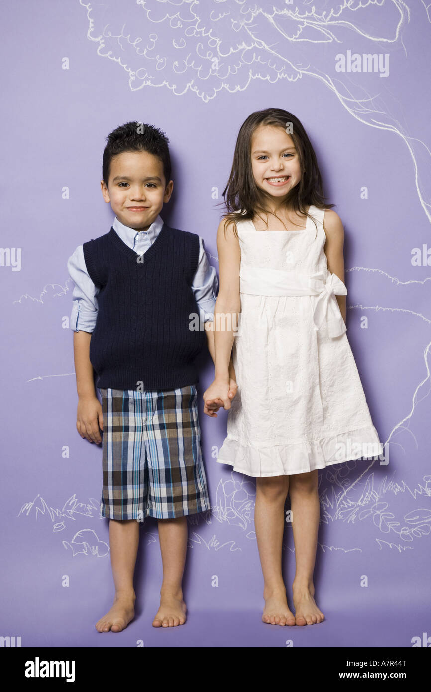 Young girl and boy holding hands smiling Stock Photo - Alamy
