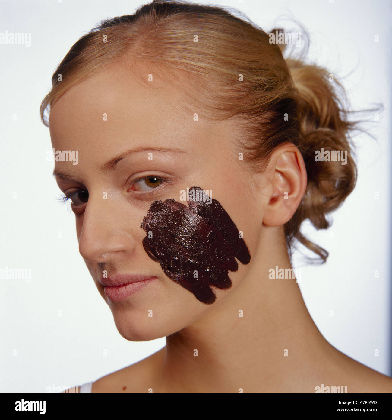 scat young indoors studio cosmetics beauty care woman young girl 20 25 blonde face  cheek mudpack mask cosmetic mud scat chocolate nurse Stock Photo - Alamy