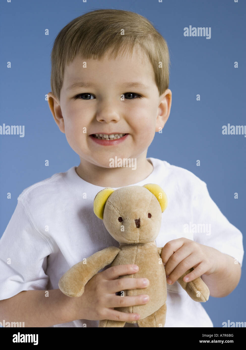 Boy holding teddy bear smiling Stock Photo - Alamy