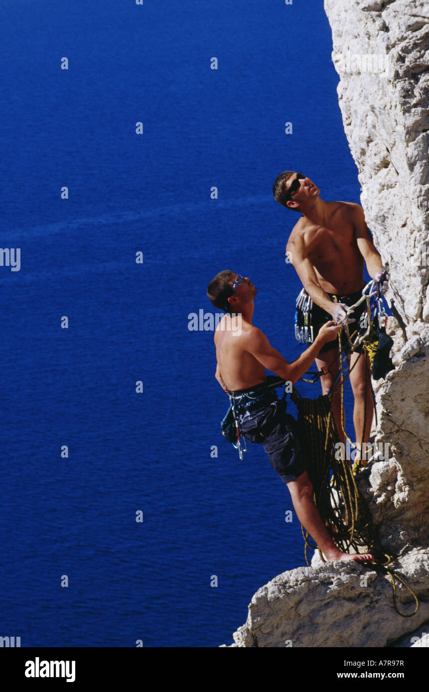 Two men climbing mountain with harnesses and ropes Stock Photo - Alamy
