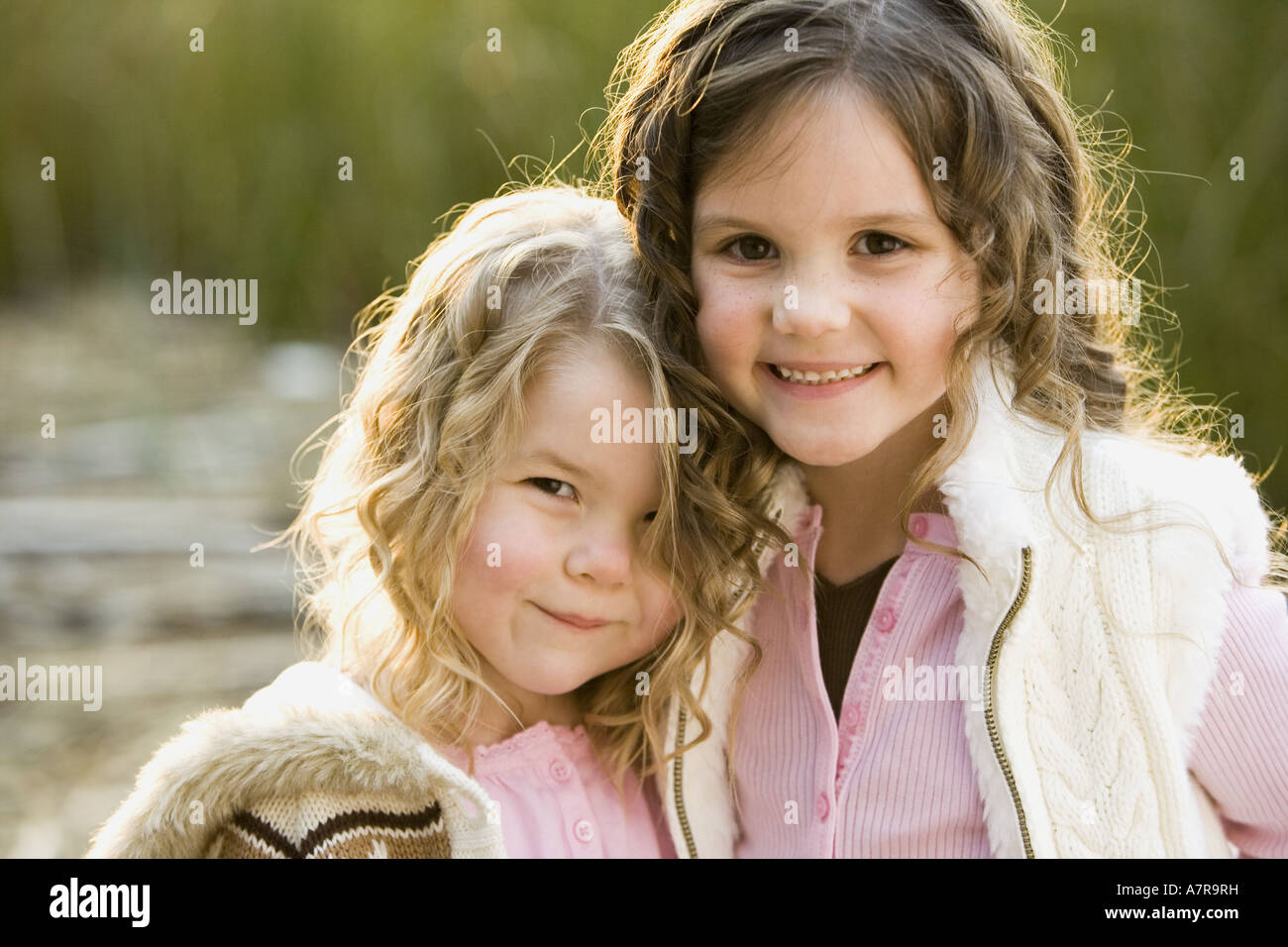 Portrait of two girls smiling and hugging outdoors Stock Photo - Alamy