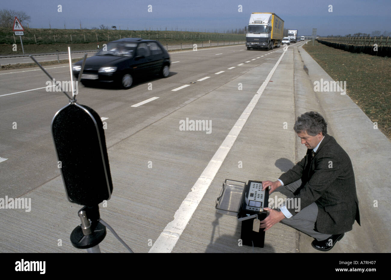 Environmental health officer measures sound decibel level on road bypass Cirencester England Stock Photo