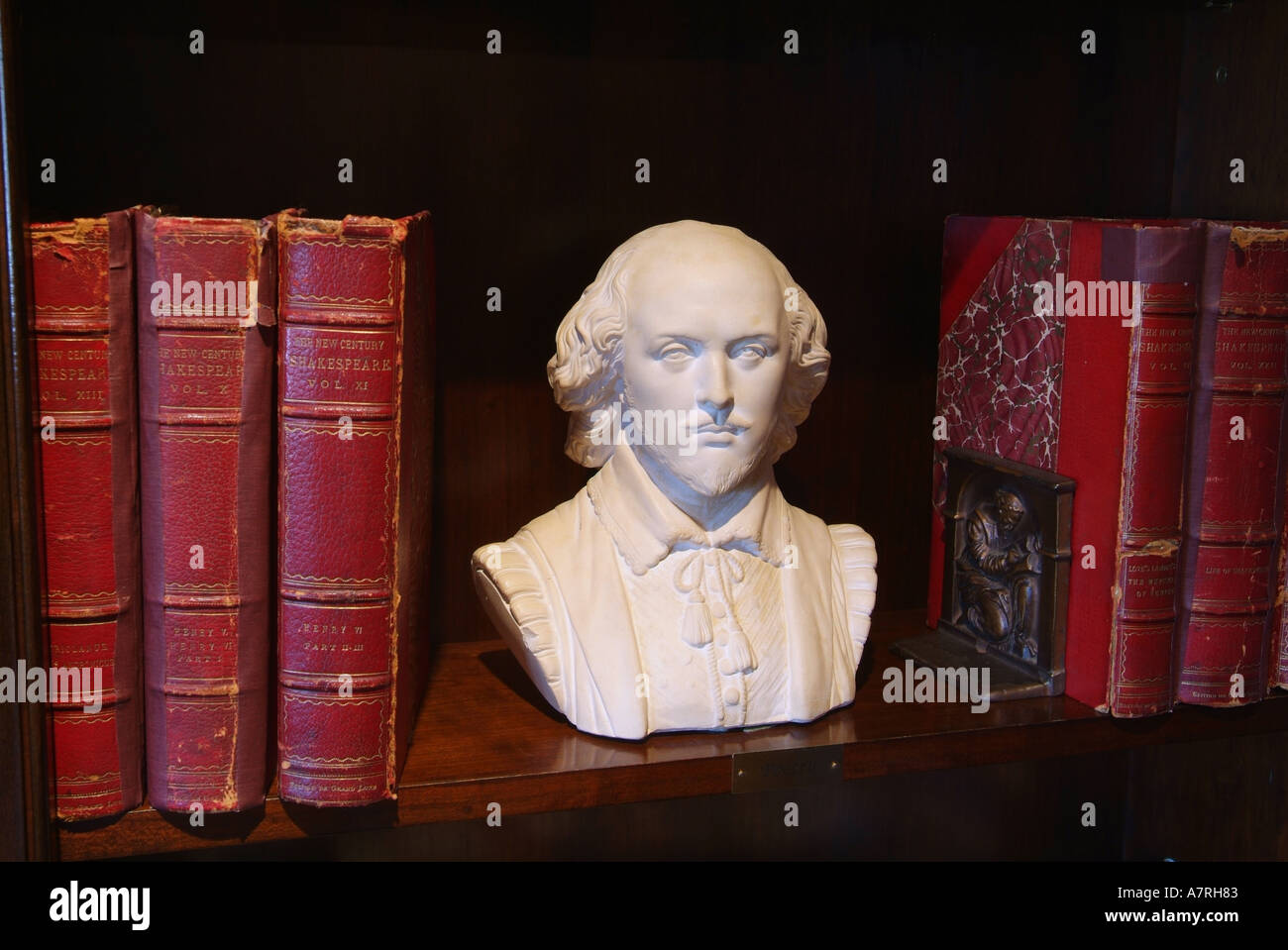 Bust of William Shakespeare and old books in a library Stock Photo